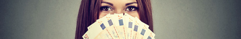 Frau hält sich einen Fächer aus 50-Euro-Scheinen vor das Gesicht